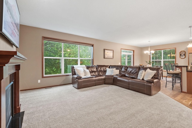 4027 148th Ln NE, Ham Lake, MN 55304 - living area with healthy amount of natural light, a fireplace, a chandelier, and carpet