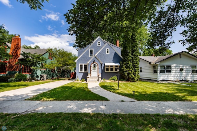 1345 4th St N, Fargo, ND 58102 - view of front of property featuring a front lawn, a chimney, and driveway