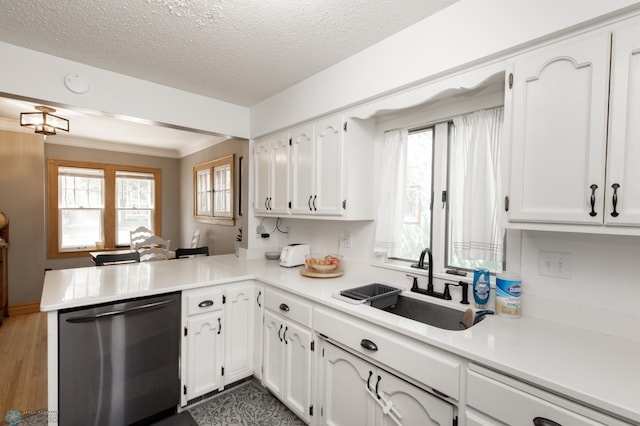 1345 4th St N, Fargo, ND 58102 - kitchen with stainless steel dishwasher, a sink, a peninsula, white cabinetry, and light countertops