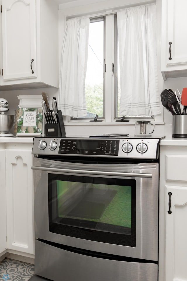 1345 4th St N, Fargo, ND 58102 - kitchen featuring stainless steel electric range, white cabinets, and light countertops