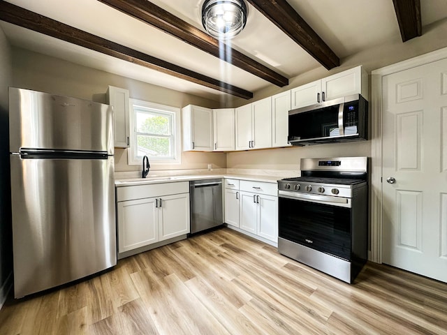 951 13th Ave NE, Rochester, MN 55906 - kitchen featuring appliances with stainless steel finishes, a sink, beamed ceiling, light countertops, and white cabinetry