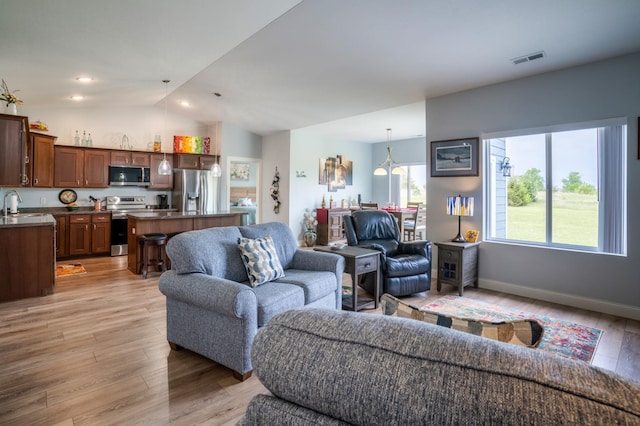 1320 Whiting Rd NW Unit 71, Bemidji, MN 56601 - living area featuring lofted ceiling, light wood-style flooring, and baseboards