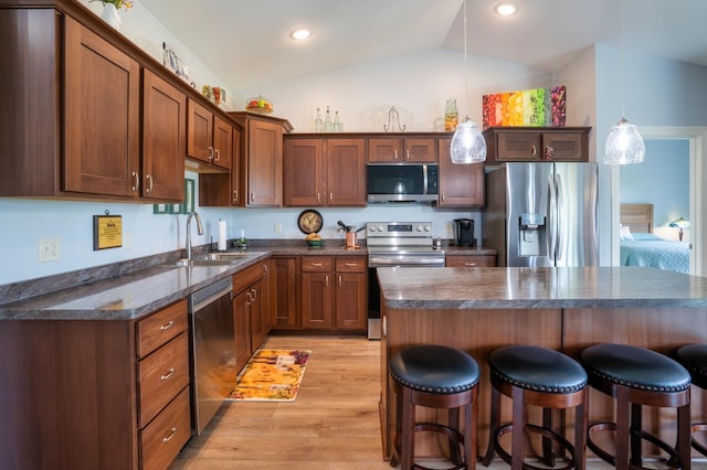 1320 Whiting Rd NW Unit 71, Bemidji, MN 56601 - kitchen with stainless steel appliances, a sink, dark countertops, vaulted ceiling, and a kitchen breakfast bar