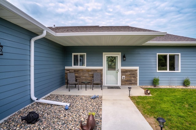1320 Whiting Rd NW Unit 71, Bemidji, MN 56601 - entrance to property featuring a yard, roof with shingles, and a patio area