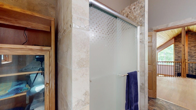 4251 Sugar Pt, Orr, MN 55771 - bathroom with a stall shower, toilet, stone finish floors, and lofted ceiling