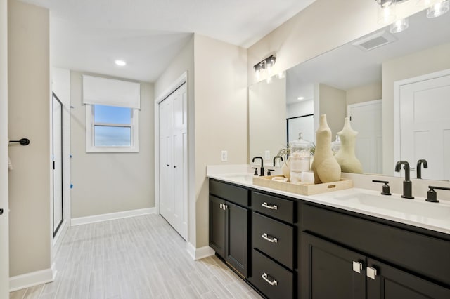 14950 144th Ave N, Dayton, MN 55327 - full bathroom with double vanity, baseboards, a stall shower, recessed lighting, and wood finished floors
