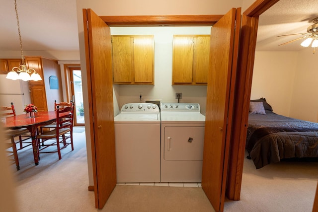 2842 19th Ave NW, Rochester, MN 55901 - washroom featuring cabinet space, separate washer and dryer, light carpet, ceiling fan, and a chandelier