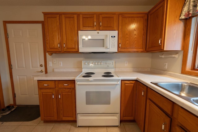 2842 19th Ave NW, Rochester, MN 55901 - kitchen featuring white appliances, brown cabinetry, light tile patterned flooring, and light countertops