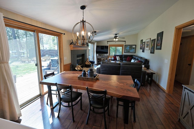 10151 Sandy Beach Rd, Round Lake Twp, WI 54843 - dining area with a brick fireplace, dark wood-style floors, a ceiling fan, a chandelier, and baseboards