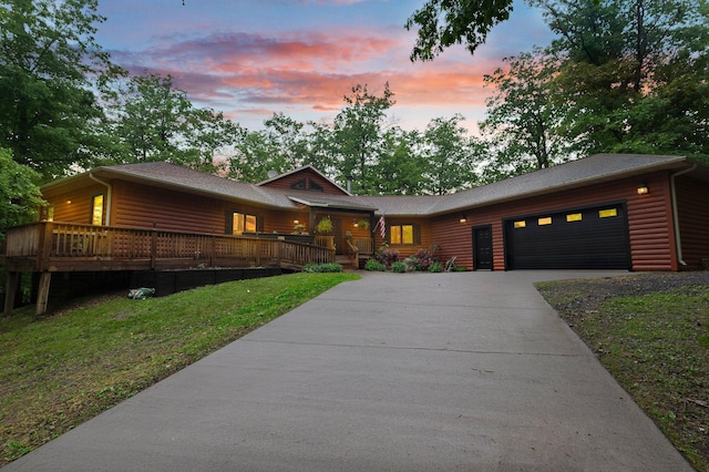 2207 Barron Polk St, Comstock, WI 54826 - view of front of home featuring concrete driveway, a garage, a lawn, log veneer siding, and a wooden deck