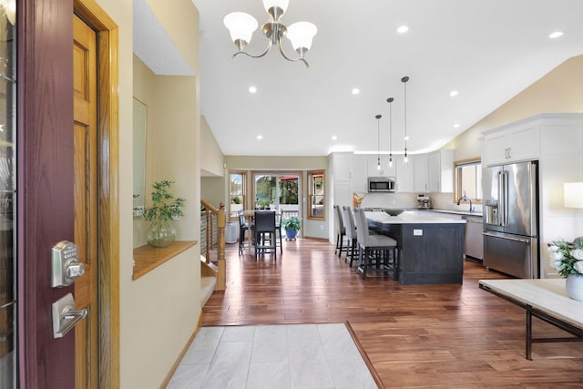 5630 Oak View Ct, Savage, MN 55378 - kitchen featuring appliances with stainless steel finishes, vaulted ceiling, a chandelier, light countertops, and a kitchen island