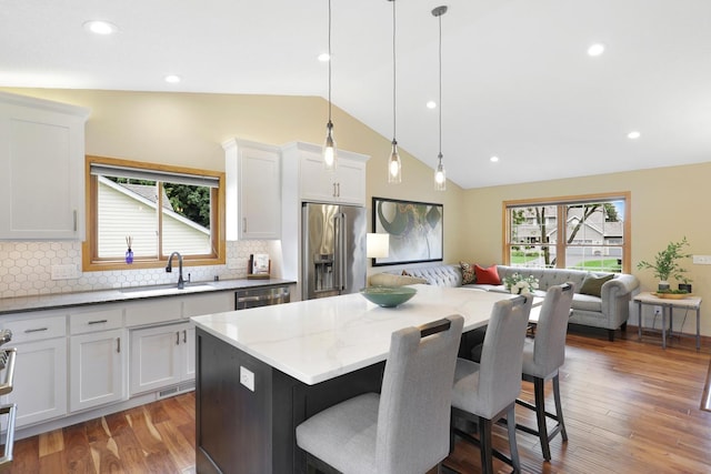 5630 Oak View Ct, Savage, MN 55378 - kitchen featuring lofted ceiling, appliances with stainless steel finishes, a breakfast bar, healthy amount of natural light, and backsplash