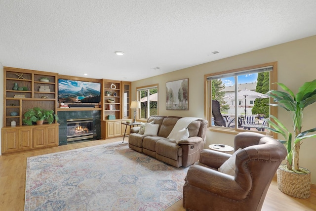 5630 Oak View Ct, Savage, MN 55378 - living room featuring light wood-style flooring, a textured ceiling, a glass covered fireplace, and recessed lighting