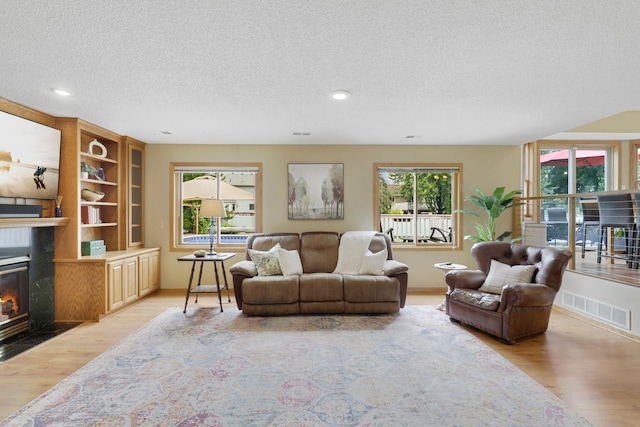 5630 Oak View Ct, Savage, MN 55378 - living area featuring a fireplace with flush hearth, light wood-type flooring, a textured ceiling, and recessed lighting