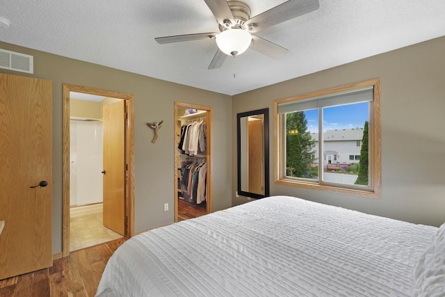 5630 Oak View Ct, Savage, MN 55378 - bedroom with wood finished floors, a spacious closet, ensuite bathroom, and ceiling fan