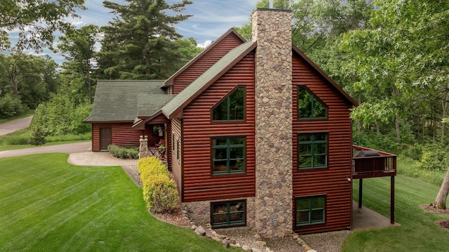 31839 Cree Bay Cir, Pelican Twp, MN 56472 - view of side of home with a lawn, a shingled roof, a chimney, and a wooden deck