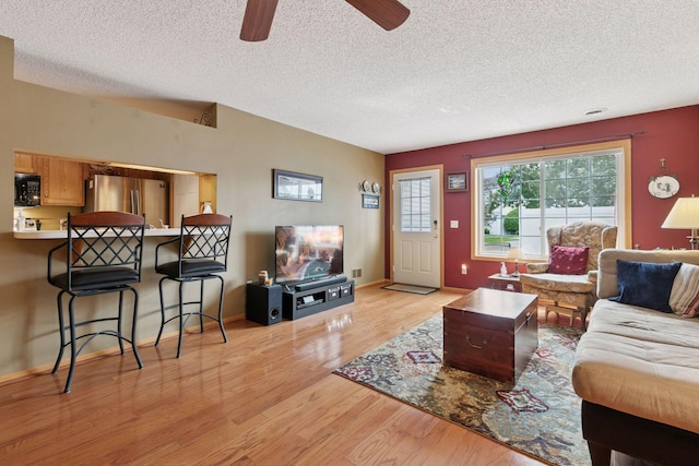 14617 Evergreen Trl Unit 75, Apple Valley, MN 55124 - living area with light wood-type flooring, a textured ceiling, ceiling fan, and baseboards