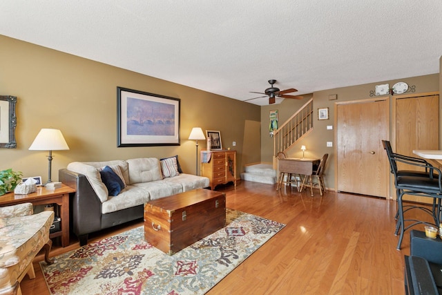 14617 Evergreen Trl Unit 75, Apple Valley, MN 55124 - living area with stairs, ceiling fan, light wood-style flooring, and a textured ceiling