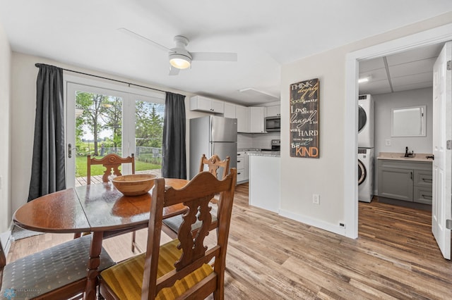 1138 20th St N, Moorhead, MN 56560 - dining area with stacked washer / dryer, light wood-style flooring, a ceiling fan, and baseboards
