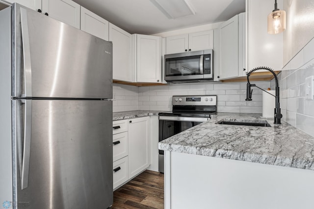 1138 20th St N, Moorhead, MN 56560 - kitchen with appliances with stainless steel finishes, a sink, tasteful backsplash, white cabinets, and dark wood-type flooring