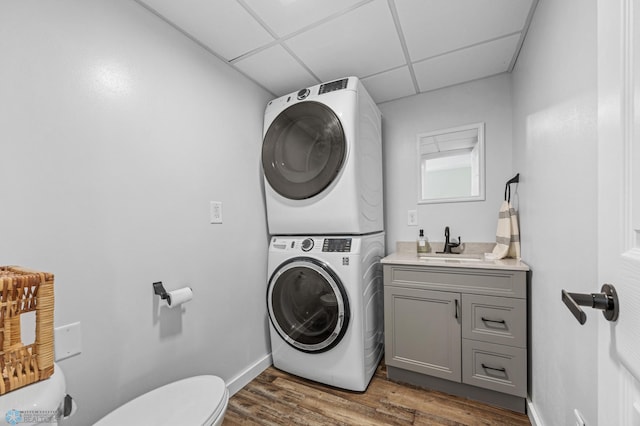 1138 20th St N, Moorhead, MN 56560 - laundry room featuring stacked washer and clothes dryer, dark wood-style flooring, and baseboards