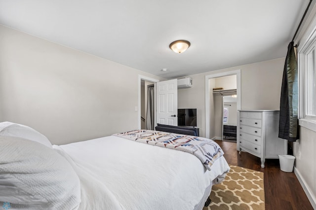 1138 20th St N, Moorhead, MN 56560 - bedroom featuring a wall mounted air conditioner, dark wood-style flooring, and baseboards