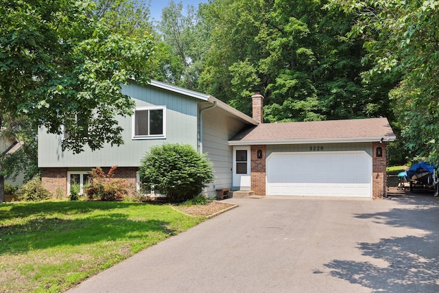 3228 Spruce Trl SW, Prior Lake, MN 55372 - tri-level home featuring brick siding, asphalt driveway, a garage, a front lawn, and a chimney