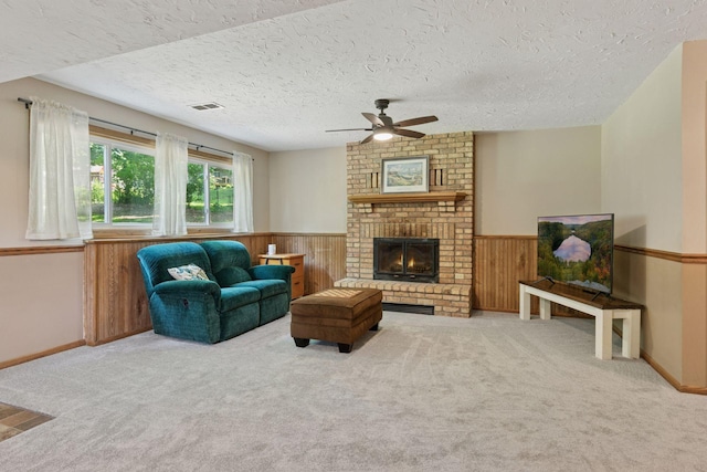 3228 Spruce Trl SW, Prior Lake, MN 55372 - carpeted living area with ceiling fan, a wainscoted wall, a textured ceiling, a brick fireplace, and wood walls