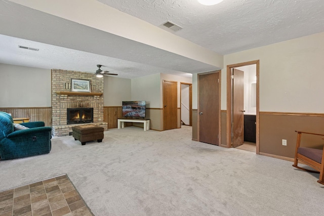 3228 Spruce Trl SW, Prior Lake, MN 55372 - carpeted living area with a textured ceiling, wainscoting, ceiling fan, and a fireplace