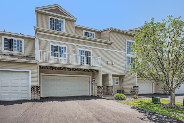 7754 Lachman Ave NE, Otsego, MN 55301 - townhome / multi-family property featuring driveway, cooling unit, brick siding, and an attached garage