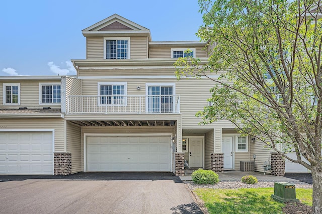 7754 Lachman Ave NE, Otsego, MN 55301 - townhome / multi-family property with brick siding, a balcony, cooling unit, and driveway