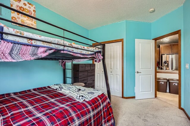 7754 Lachman Ave NE, Otsego, MN 55301 - carpeted bedroom with stainless steel refrigerator with ice dispenser, a closet, a textured ceiling, and baseboards