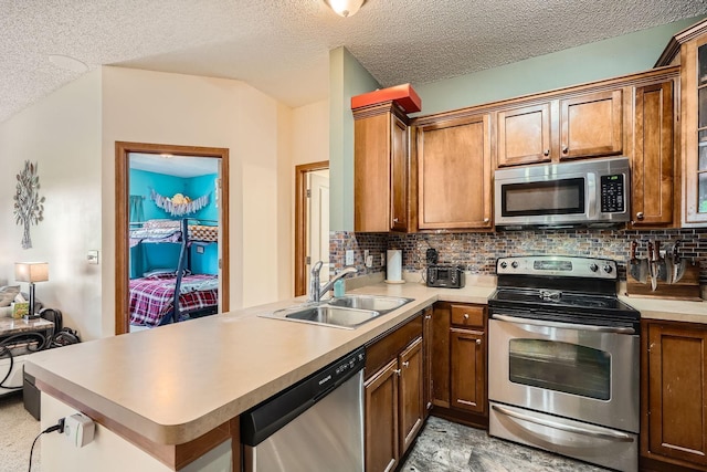 7754 Lachman Ave NE, Otsego, MN 55301 - kitchen with appliances with stainless steel finishes, a sink, a peninsula, decorative backsplash, and light countertops