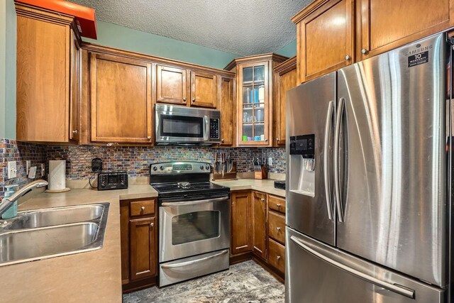 7754 Lachman Ave NE, Otsego, MN 55301 - kitchen with appliances with stainless steel finishes, a sink, brown cabinets, light countertops, and decorative backsplash