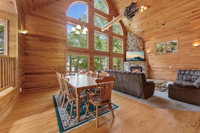 6031 232nd St W, Faribault, MN 55021 - dining area featuring high vaulted ceiling, plenty of natural light, wood walls, a fireplace, and light wood-style floors
