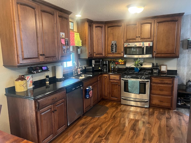 20906 624th Ave, Litchfield, MN 55355 - kitchen featuring appliances with stainless steel finishes, a sink, dark countertops, dark wood-style flooring, and a textured ceiling