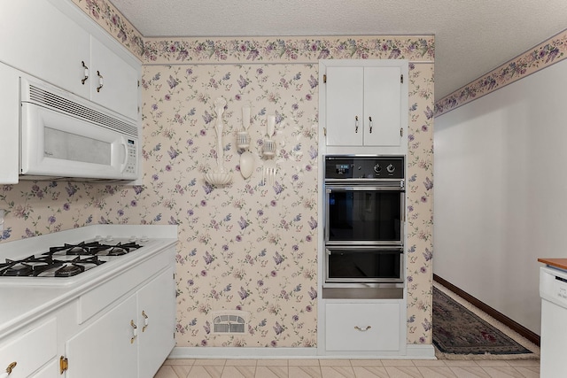 6379 Hodgson Rd, Lino Lakes, MN 55014 - kitchen with white appliances, a warming drawer, a textured ceiling, white cabinets, and light countertops