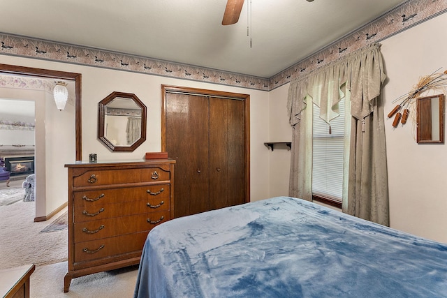 6379 Hodgson Rd, Lino Lakes, MN 55014 - bedroom featuring light carpet, a closet, a ceiling fan, and a glass covered fireplace
