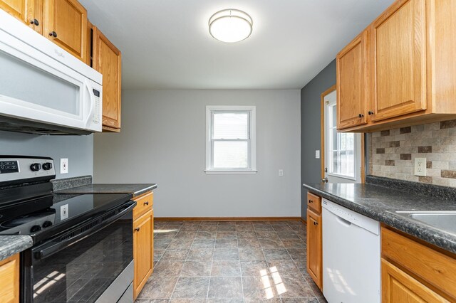 3568 6th St NW, Rochester, MN 55901 - kitchen featuring white appliances, baseboards, decorative backsplash, and dark countertops