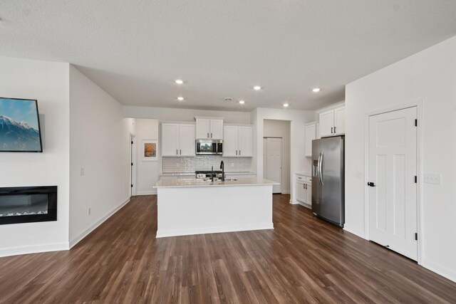 5173 Useppa Trl, Woodbury, MN 55129 - kitchen with appliances with stainless steel finishes, backsplash, dark wood-type flooring, white cabinets, and recessed lighting
