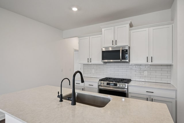 5173 Useppa Trl, Woodbury, MN 55129 - kitchen with appliances with stainless steel finishes, tasteful backsplash, light countertops, white cabinetry, and recessed lighting