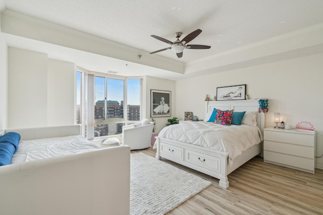 6600 Lyndale Ave S Unit 1005, Richfield, MN 55423 - bedroom featuring light wood finished floors, a ceiling fan, crown molding, and a tray ceiling