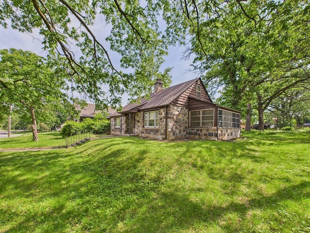 1538 8th Ave SE, Saint Cloud, MN 56304 - view of front of home with a chimney, a sunroom, a front yard, and stone siding