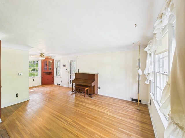 1538 8th Ave SE, Saint Cloud, MN 56304 - unfurnished living room featuring a ceiling fan, light wood-style floors, and baseboards