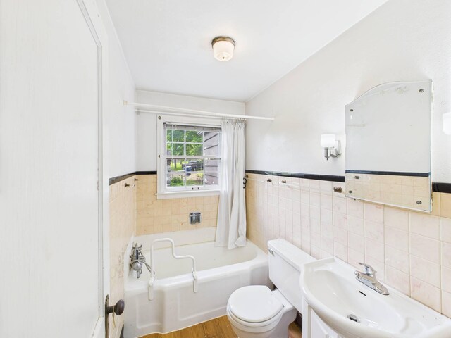 1538 8th Ave SE, Saint Cloud, MN 56304 - bathroom featuring a sink, tile walls, toilet, wood finished floors, and a wainscoted wall