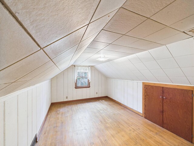 1538 8th Ave SE, Saint Cloud, MN 56304 - bonus room with light wood-type flooring, baseboards, lofted ceiling, and wood walls
