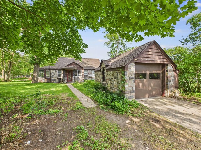 1538 8th Ave SE, Saint Cloud, MN 56304 - view of front of house featuring stone siding, concrete driveway, a shingled roof, and a front lawn