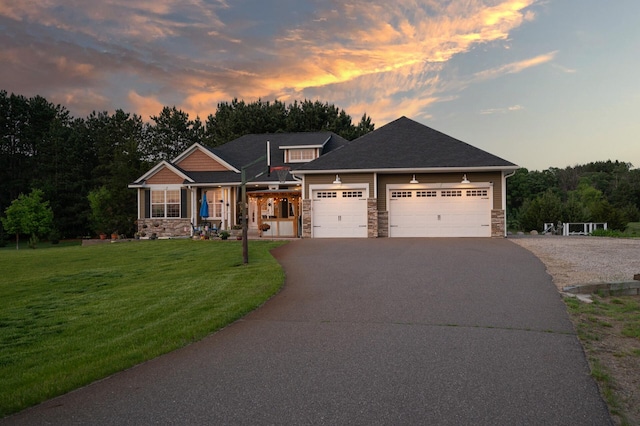 25455 145th St NW, Zimmerman, MN 55398 - craftsman-style home with stone siding, asphalt driveway, a lawn, an attached garage, and covered porch