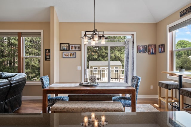25455 145th St NW, Zimmerman, MN 55398 - dining area with baseboards, wood finished floors, a chandelier, and vaulted ceiling