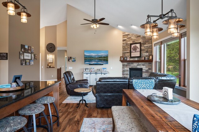 25455 145th St NW, Zimmerman, MN 55398 - living room with dark wood-type flooring, high vaulted ceiling, a ceiling fan, and a stone fireplace